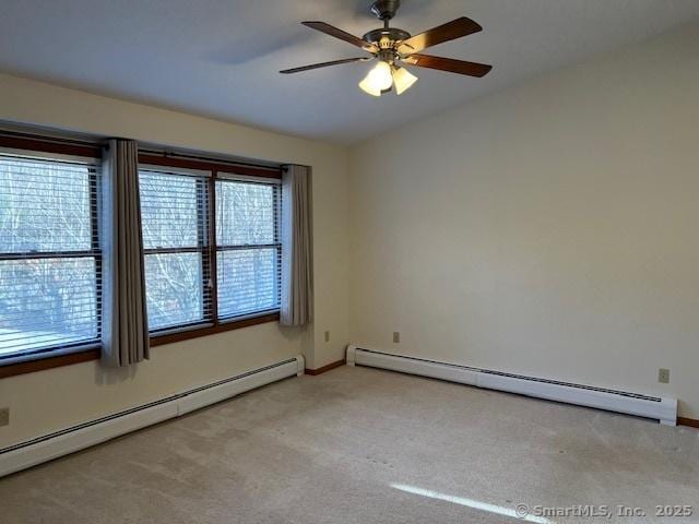 carpeted empty room featuring baseboard heating, baseboards, a ceiling fan, and vaulted ceiling