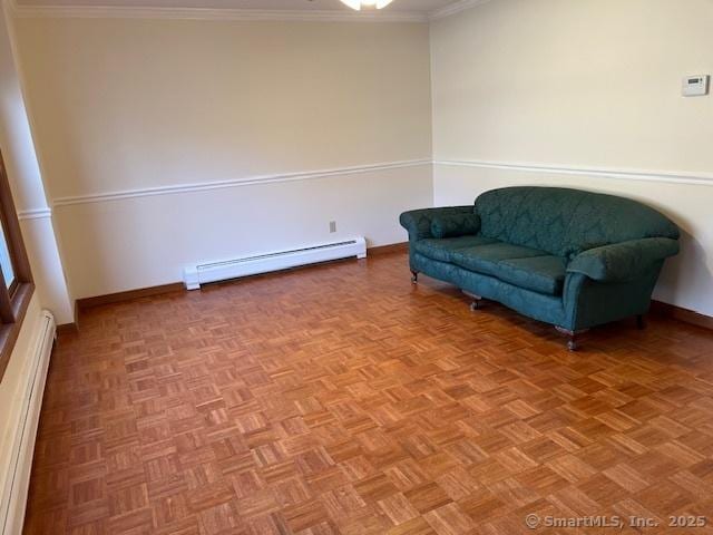 living area featuring baseboards, baseboard heating, and ornamental molding