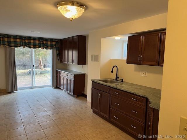 kitchen with a sink, visible vents, and dark brown cabinets