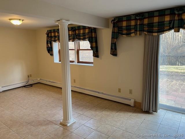 unfurnished dining area featuring light tile patterned floors, decorative columns, and baseboards