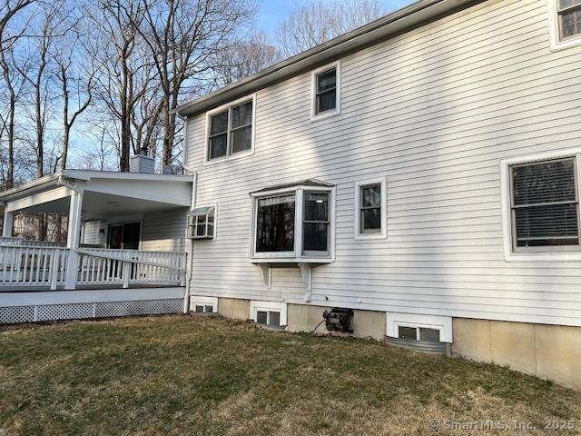 view of side of property featuring a lawn and a deck