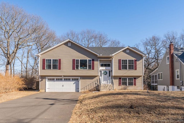 split foyer home featuring entry steps, an attached garage, and driveway