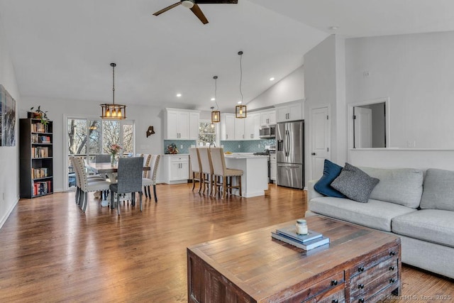 living area with high vaulted ceiling, recessed lighting, light wood finished floors, and ceiling fan