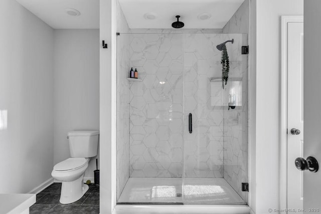 bathroom with a marble finish shower, tile patterned flooring, toilet, and baseboards