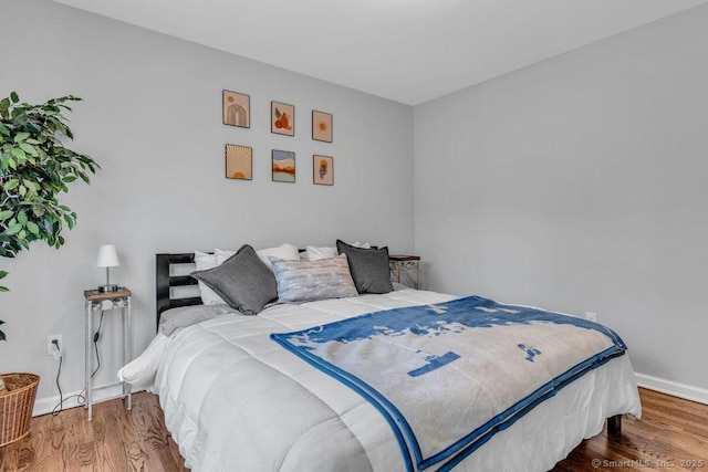 bedroom with baseboards and wood finished floors