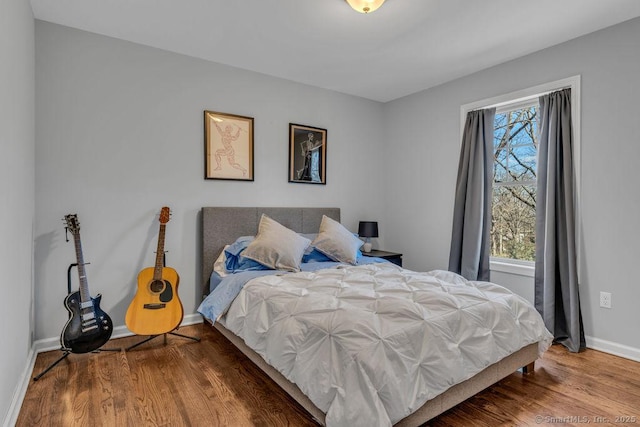 bedroom featuring baseboards and wood finished floors