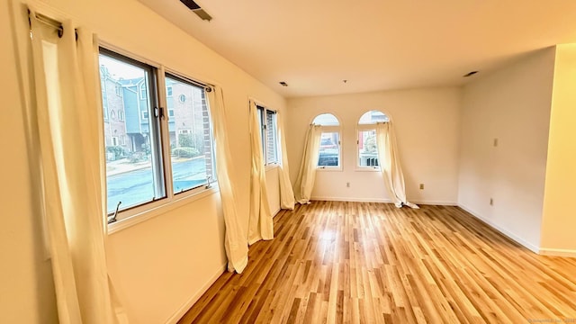 unfurnished room featuring light wood-style flooring and baseboards