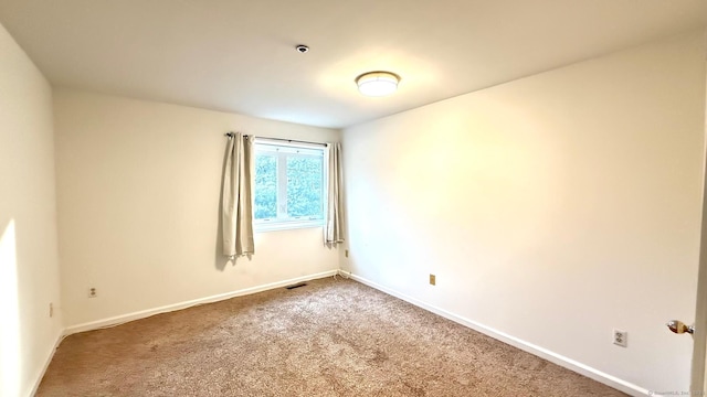 unfurnished room featuring visible vents, baseboards, and carpet flooring