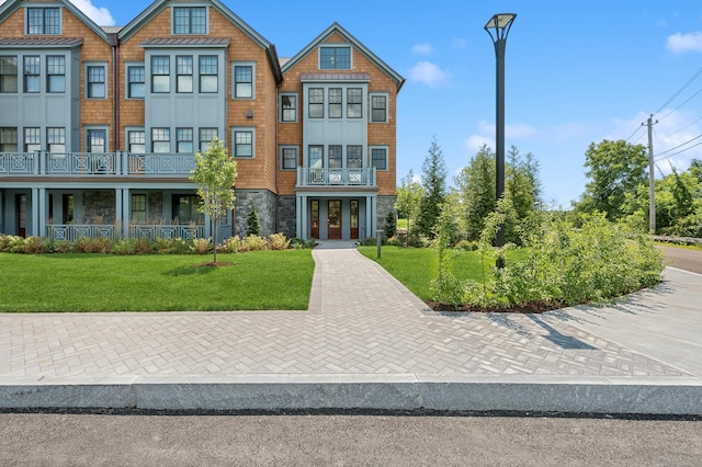 view of front of property featuring stone siding and a front lawn