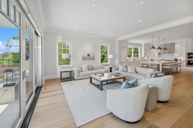 living room featuring light wood-style floors, recessed lighting, a healthy amount of sunlight, and crown molding