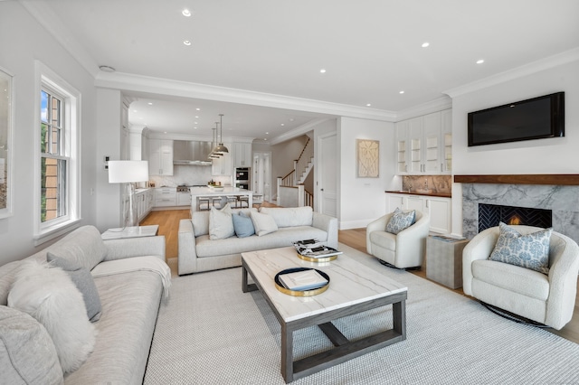 living room with light wood finished floors, recessed lighting, stairway, and a high end fireplace