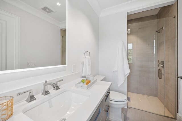 full bathroom featuring visible vents, toilet, ornamental molding, vanity, and a shower stall