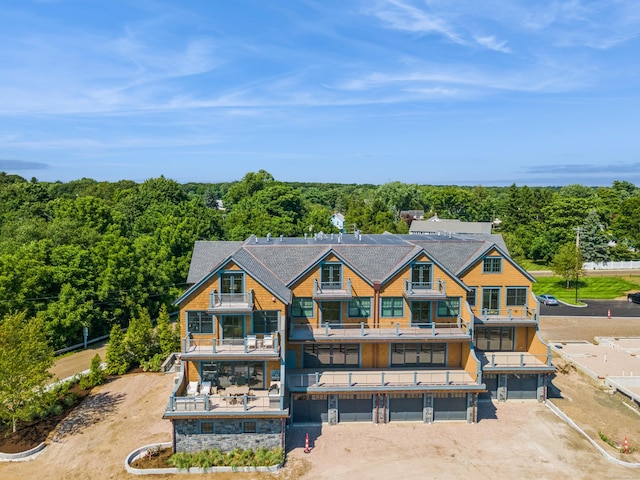 back of property featuring a garage and a wooded view