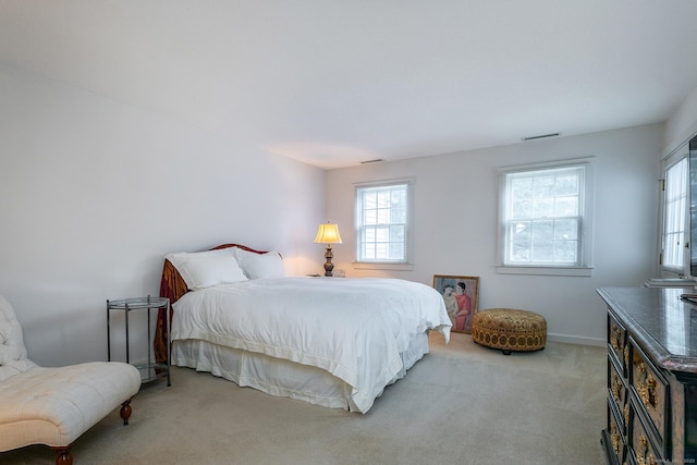 carpeted bedroom with visible vents and baseboards