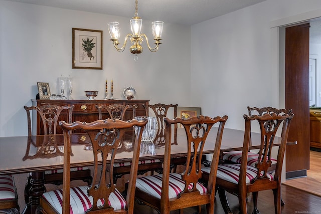 dining space with a chandelier and wood finished floors