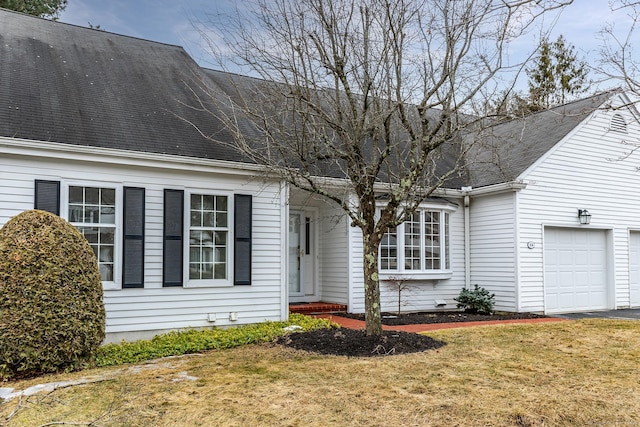 cape cod house featuring a garage, a front lawn, and a shingled roof