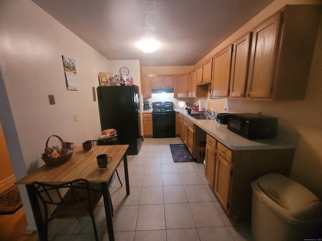 kitchen featuring light tile patterned floors, a textured ceiling, a sink, light countertops, and black appliances