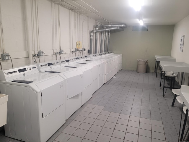 community laundry room featuring light tile patterned floors and washing machine and clothes dryer