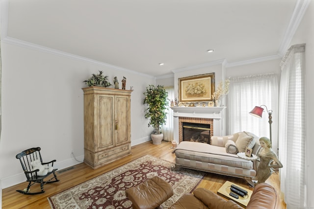 living room featuring baseboards, light wood finished floors, a brick fireplace, and crown molding