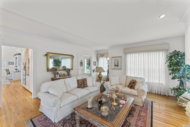 living room with light wood-style flooring, ornamental molding, and recessed lighting