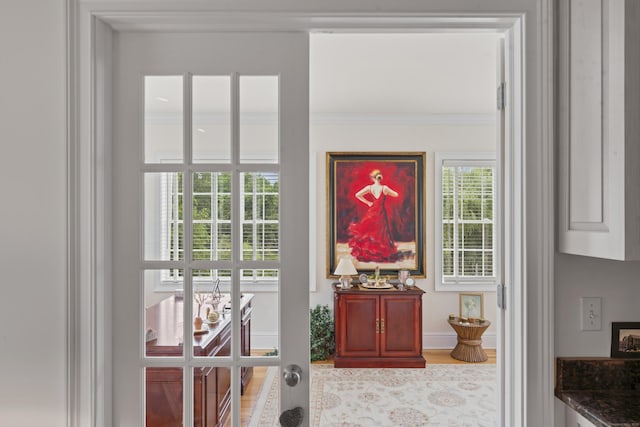 entryway with french doors, wood finished floors, and crown molding