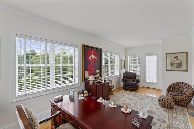 office featuring a healthy amount of sunlight, light wood finished floors, baseboards, and ornamental molding