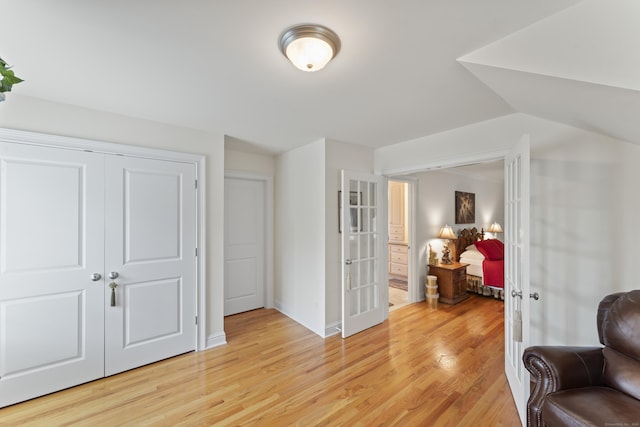 living area featuring light wood finished floors, french doors, and baseboards