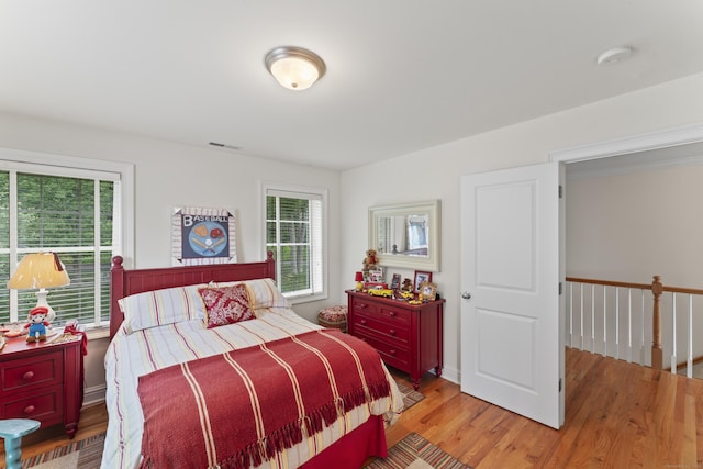 bedroom featuring multiple windows, visible vents, and light wood-style floors