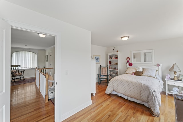 bedroom with light wood-style flooring and baseboards