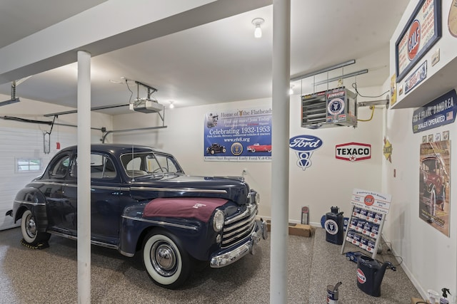 garage featuring a garage door opener and baseboards