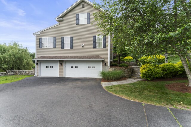 view of side of property featuring driveway and an attached garage