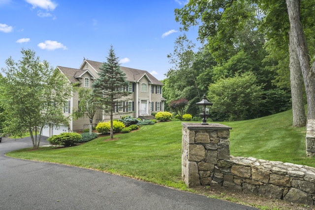 view of front facade with an attached garage, driveway, and a front lawn