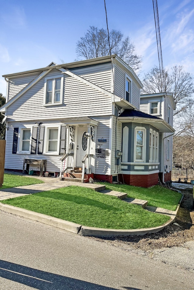 view of front of property featuring entry steps and a front yard