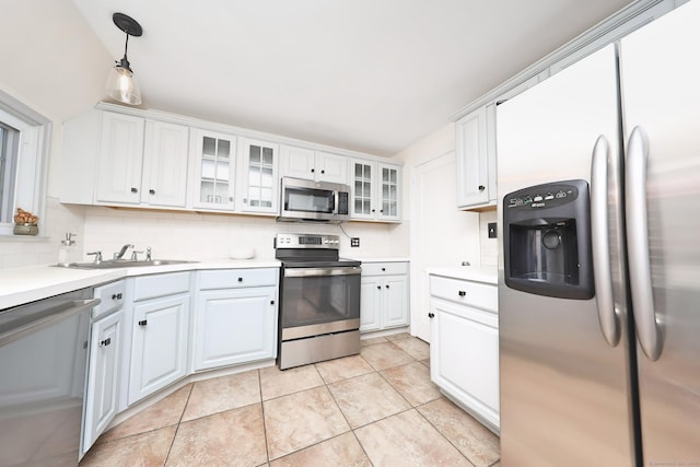 kitchen featuring appliances with stainless steel finishes, decorative backsplash, a sink, and light countertops