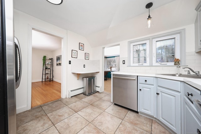 kitchen with tasteful backsplash, baseboard heating, stainless steel appliances, and a sink