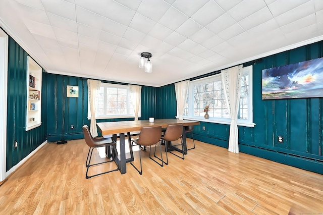 dining area with ornamental molding and wood finished floors