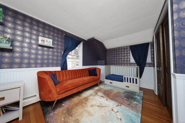 sitting room featuring a wainscoted wall, baseboard heating, wood finished floors, and wallpapered walls