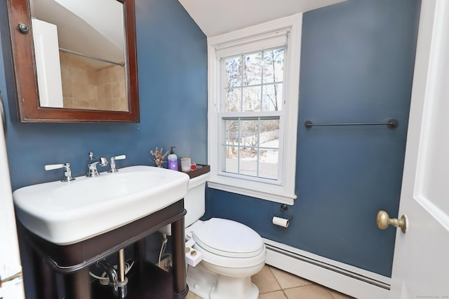 bathroom with toilet, baseboard heating, a sink, and tile patterned floors