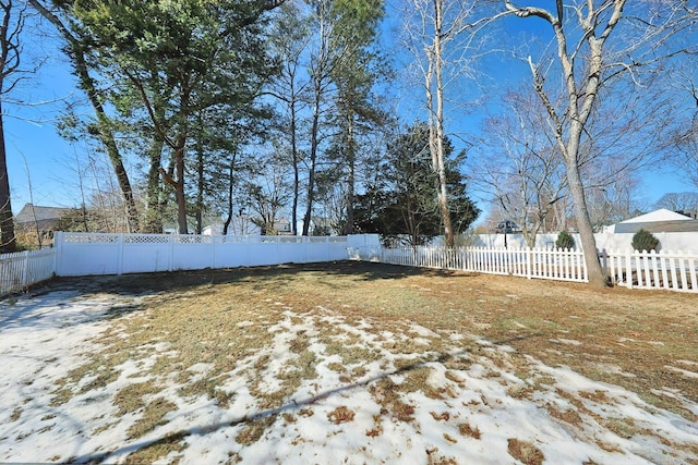 snowy yard with a fenced backyard