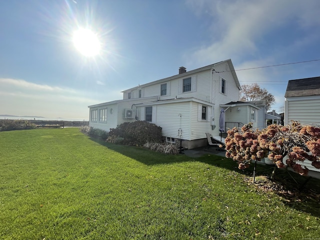 rear view of property with a lawn and a chimney