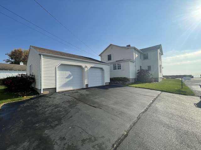 view of home's exterior featuring a lawn, an outdoor structure, and a detached garage