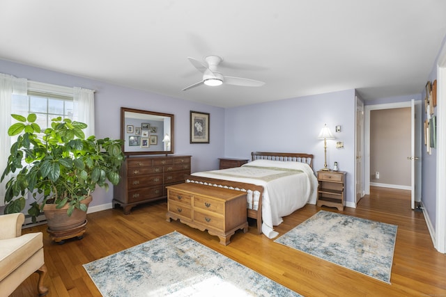 bedroom with ceiling fan, baseboards, and wood finished floors