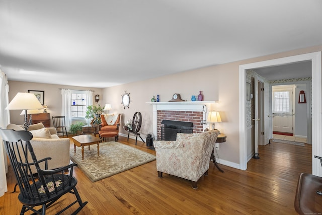 living area with wood finished floors, a wealth of natural light, and baseboards