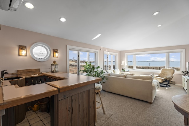 kitchen featuring recessed lighting, open floor plan, light carpet, and vaulted ceiling