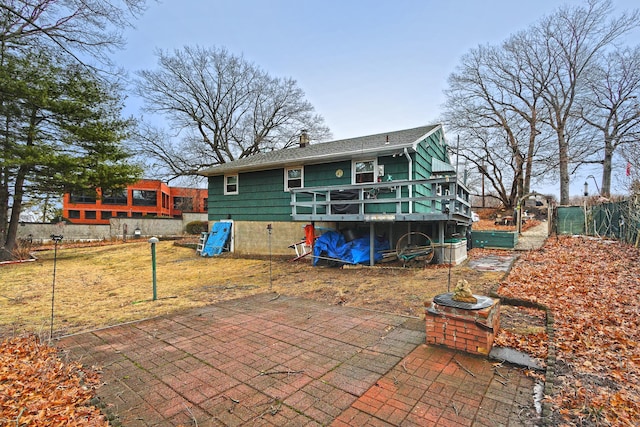 rear view of property with a patio, a chimney, and a wooden deck