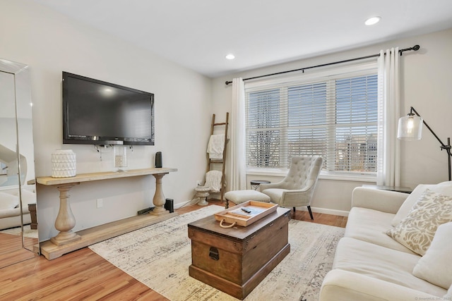 living room featuring baseboards, wood finished floors, and recessed lighting