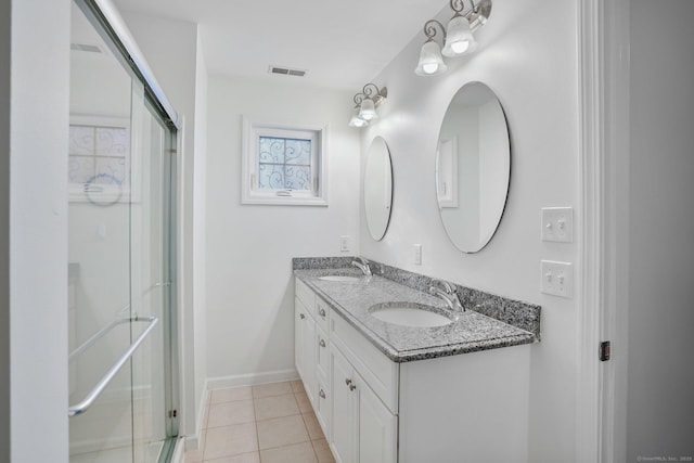 full bathroom featuring double vanity, visible vents, tile patterned flooring, an enclosed shower, and a sink