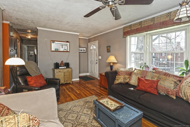 living room featuring a textured ceiling, ornamental molding, wood finished floors, and ceiling fan