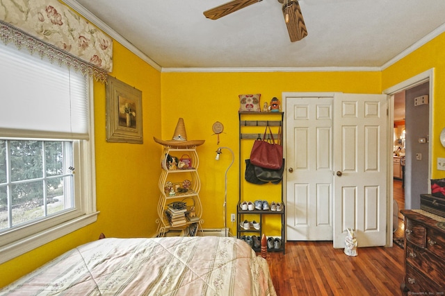 bedroom with ceiling fan, wood finished floors, and crown molding