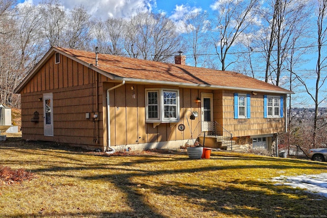 view of front of home featuring a front lawn, board and batten siding, and a chimney